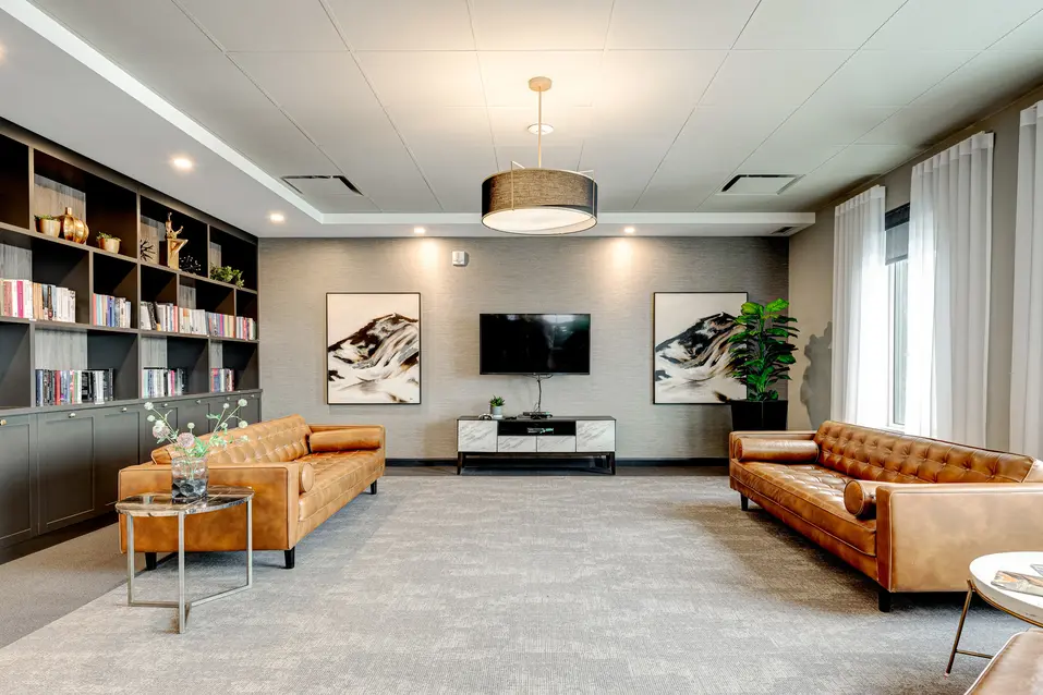 Salon avec bibliothèque, téléviseur et canapés en cuir, Chartwell Des Chutes / Lounge with bookshelf, television, and leather sofas, Chartwell Des Chutes
