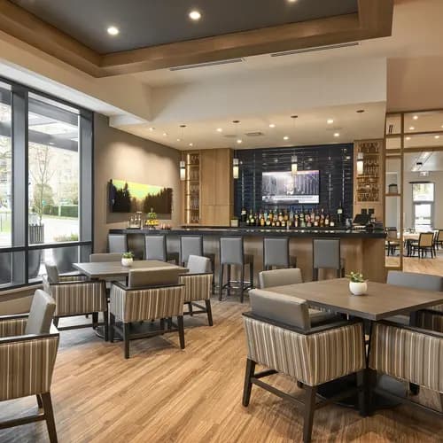 Chartwell Victoria Harbour's elegant bar with stools and bistro dining sets.