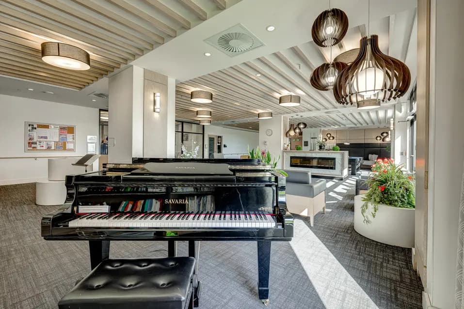 Salon avec piano à queue et cheminée à Chartwell Le Normandie / Lounge with grand piano and fireplace at Chartwell Le Normandie