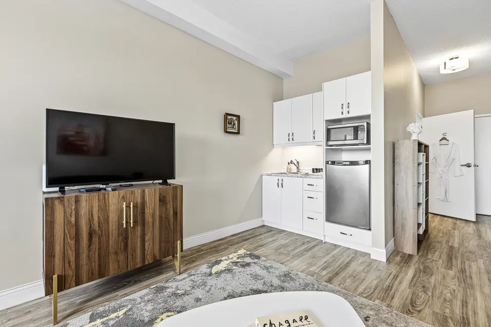 Compact kitchenette with white cabinets and stainless appliances at Chartwell Stillwater Creek / Kitchenette compacte avec armoires blanches et électroménagers en acier inoxydable à Chartwell Stillwater Creek
