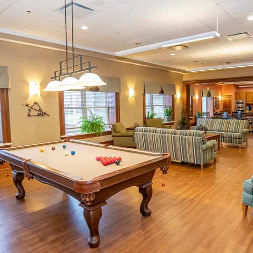 Activity room with billiards table and lounge seating at Chartwell Westhill / Salle d’activités avec table de billard et coin détente à Chartwell Westhill