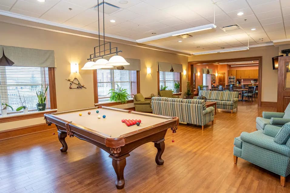 Activity room with billiards table and lounge seating at Chartwell Westhill / Salle d’activités avec table de billard et coin détente à Chartwell Westhill