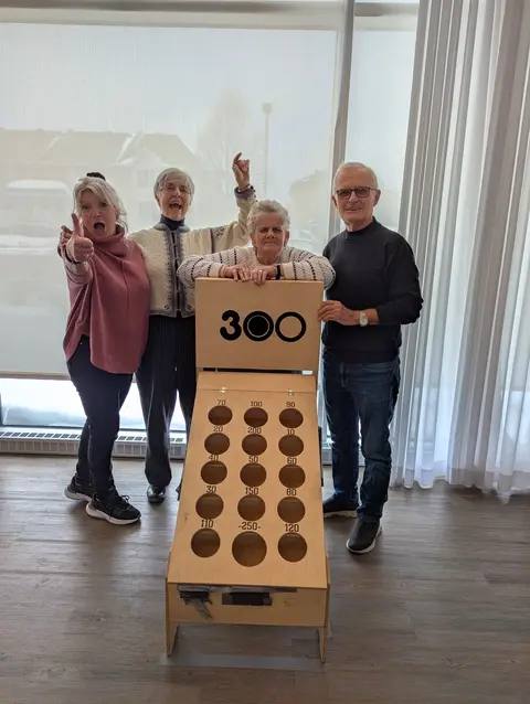 Group of seniors playing an indoor game with a wooden scoreboard