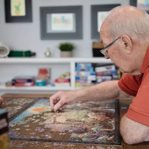 Senior resident engrossed in finishing a big puzzle