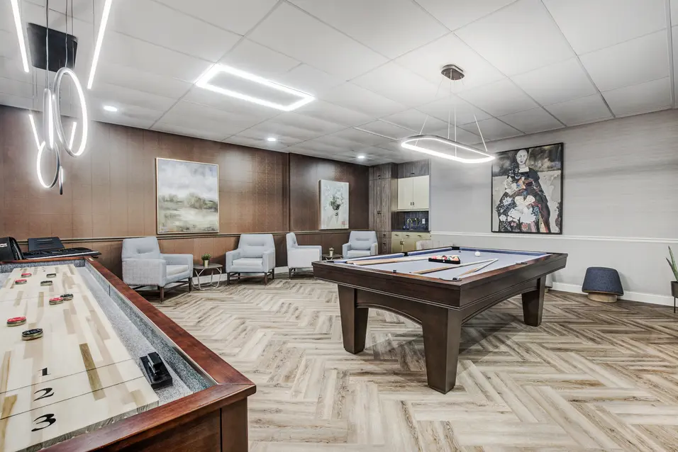 Games room with billiards table and shuffleboard at Chartwell ValleyVista / Salle de jeux avec table de billard et jeu de palets à Chartwell ValleyVista