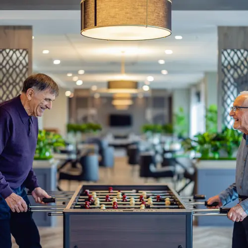 Senior men are enjoying playing table soccer / Les seniors s'amusent à jouer au baby-foot