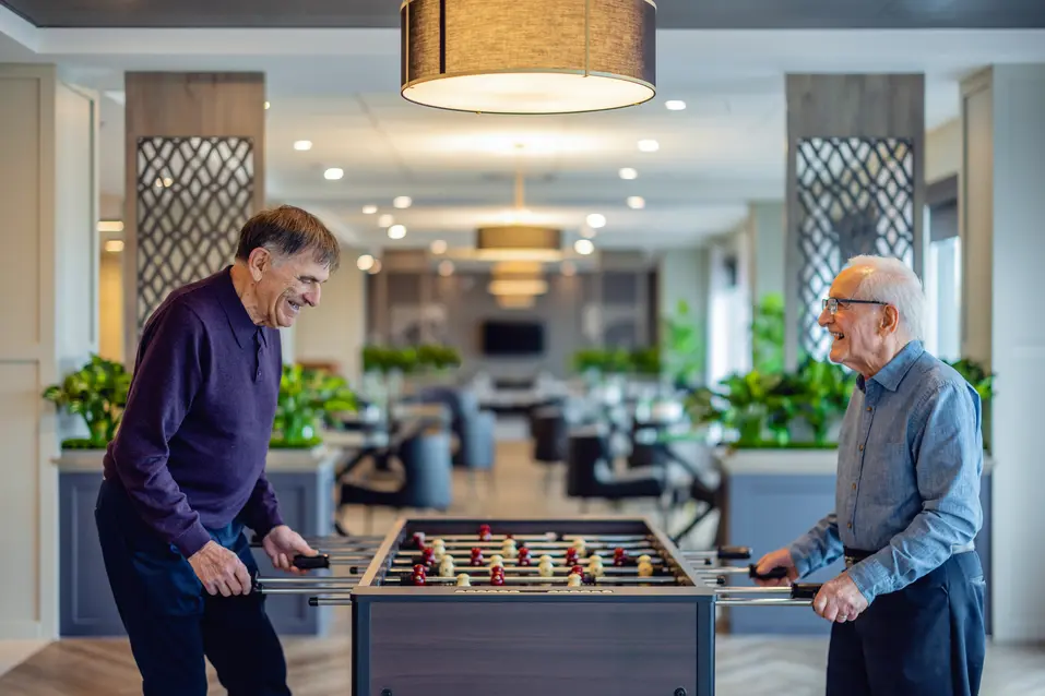 Senior men are enjoying playing table soccer / Les seniors s'amusent à jouer au baby-foot
