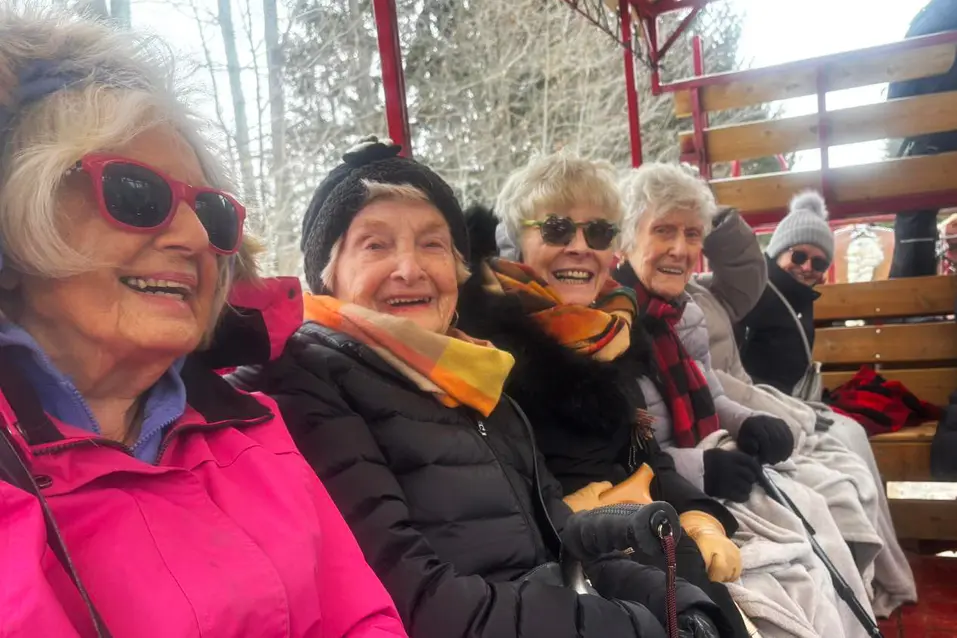 Residents sitting together on an outdoor wagon ride / Résidents assis ensemble lors d’une promenade en chariot extérieur