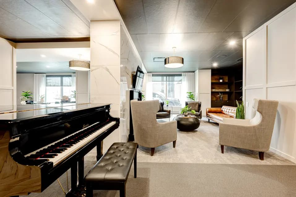 Salon élégant avec piano noir et fauteuils confortables, Chartwell Des Chutes / Elegant lounge with black piano and comfortable armchairs, Chartwell Des Chutes