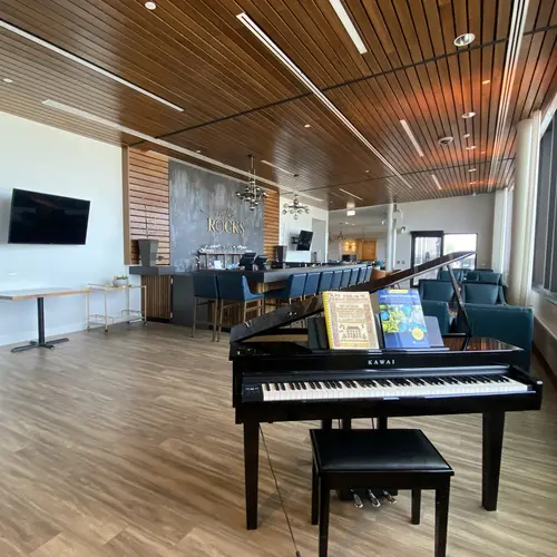 Modern bar lounge with piano and high ceilings at Chartwell Riverstone / Bar-salon moderne avec piano et hauts plafonds à Chartwell Riverstone