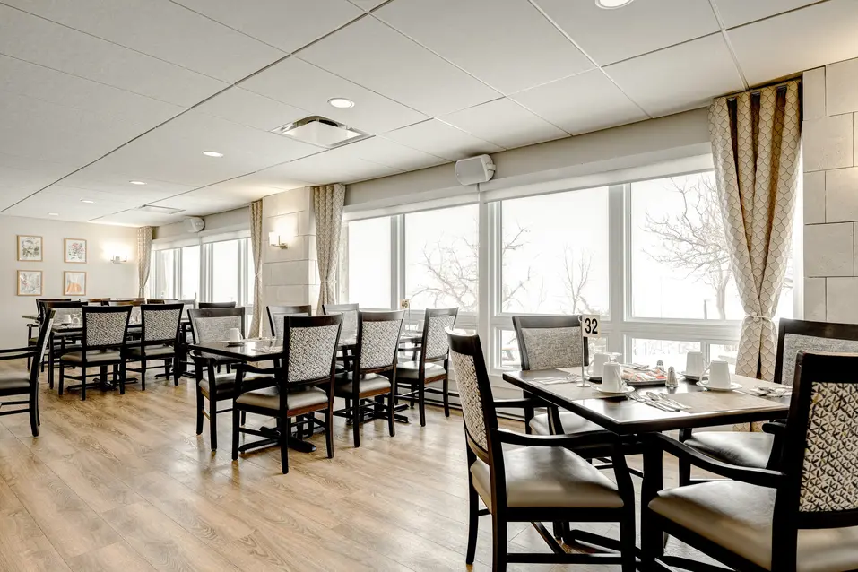 Salle à manger spacieuse avec tables dressées à Chartwell Les Écores / Spacious dining room with set tables at Chartwell Les Écores