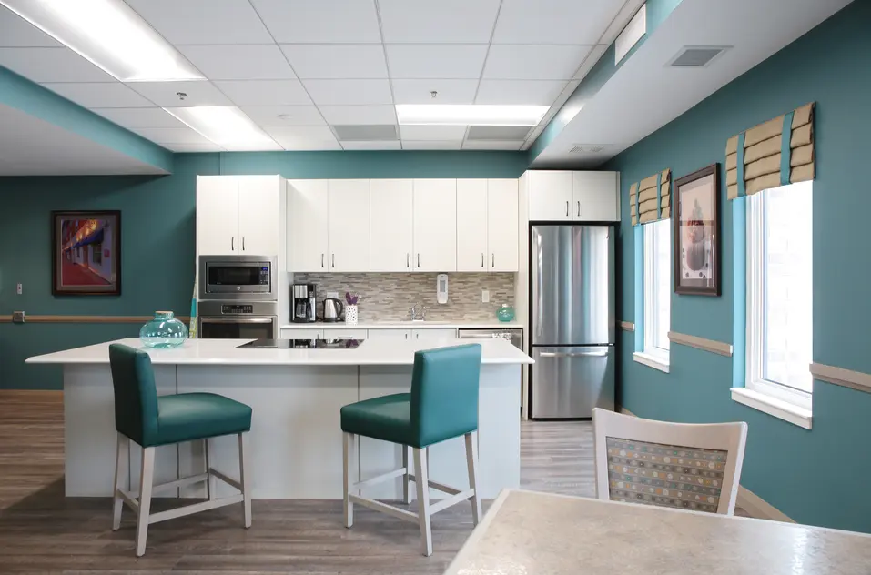 Modern kitchen island with teal stools at Chartwell Dorchester Terrace / Îlot de cuisine moderne avec tabourets turquoise à Chartwell Dorchester Terrace