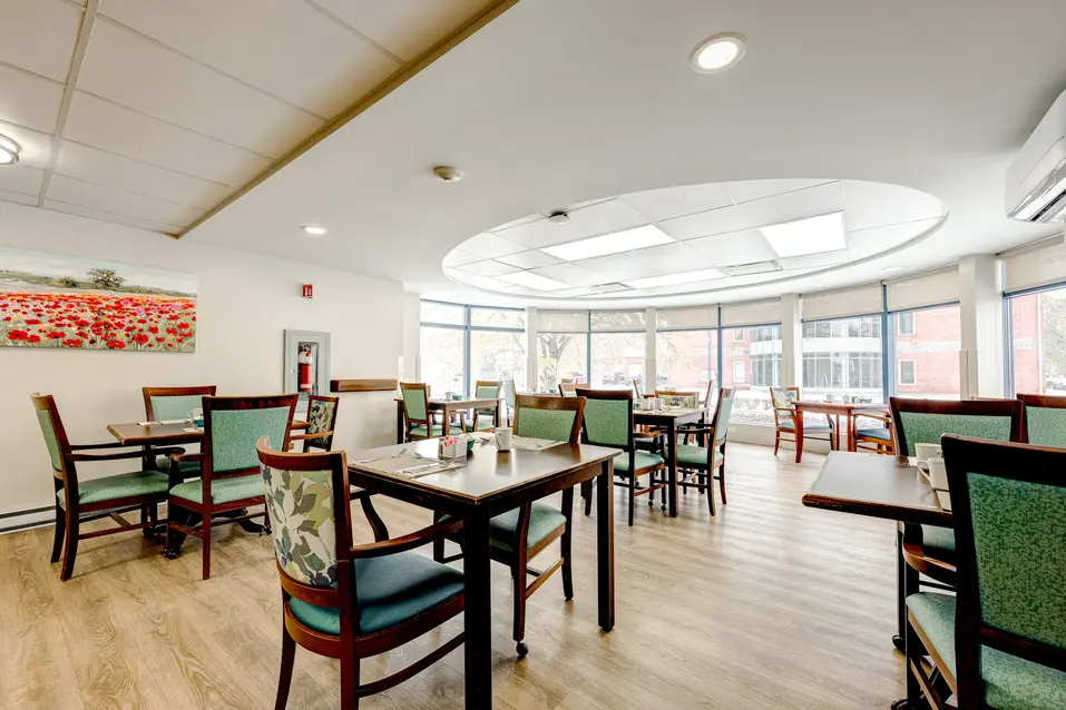 Salle à manger lumineuse avec grandes fenêtres à Chartwell Oasis St-Jean / Bright dining room with large windows at Chartwell Oasis St-Jean