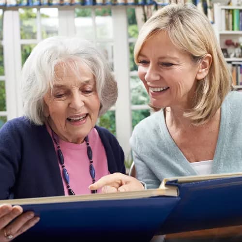 Senior woman with daughter looking at photos