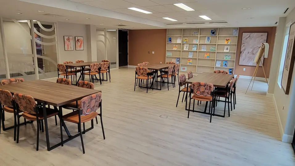 Bright art room with tables and display shelves at Chartwell Riverstone / Salle d’art lumineuse avec tables et étagères d’exposition à Chartwell Riverstone