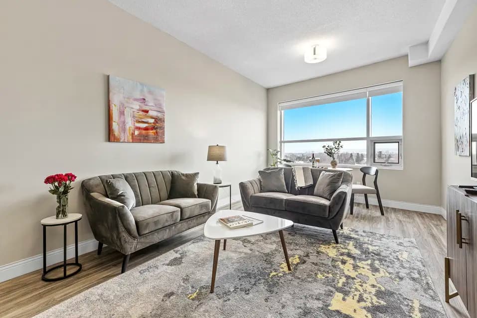 Bright living room with modern furniture and large window at Chartwell Stillwater Creek / Salon lumineux avec mobilier moderne et grande fenêtre à Chartwell Stillwater Creek
