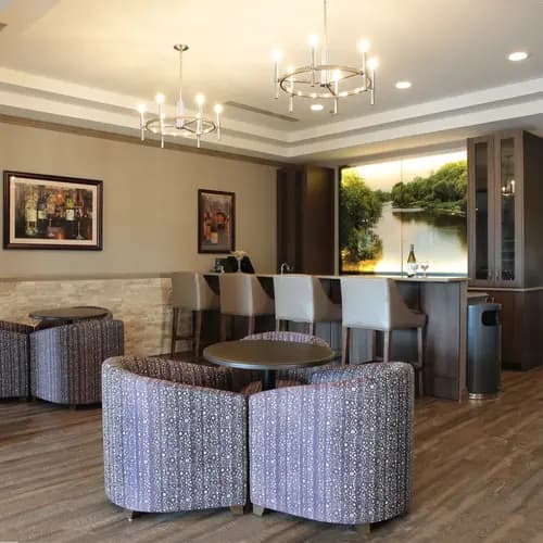 Elegant bar lounge with stools and landscape art at Chartwell Dorchester Terrace / Salon-bar élégant avec tabourets et mural paysager à Chartwell Dorchester Terrace