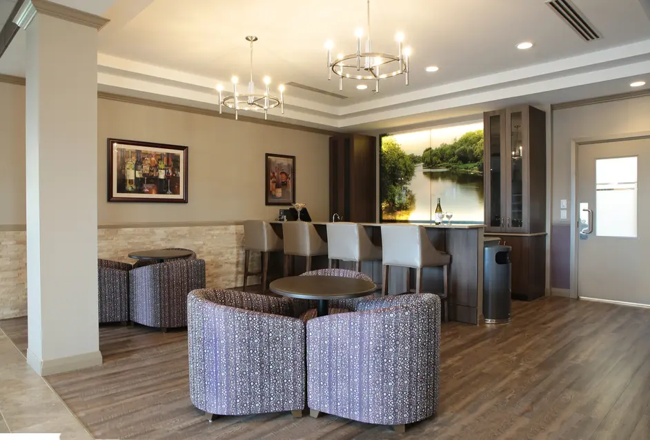 Elegant bar lounge with stools and landscape art at Chartwell Dorchester Terrace / Salon-bar élégant avec tabourets et mural paysager à Chartwell Dorchester Terrace