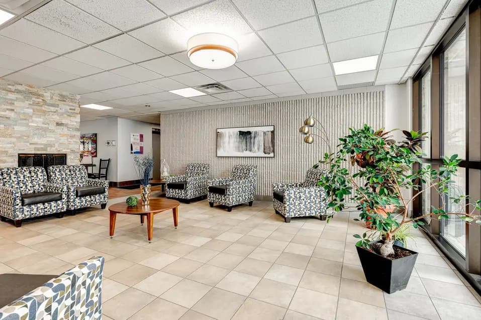 Aire d’accueil avec fauteuils et grande fenêtre à Les Écores / Lobby seating area with chairs and large window at Les Écores