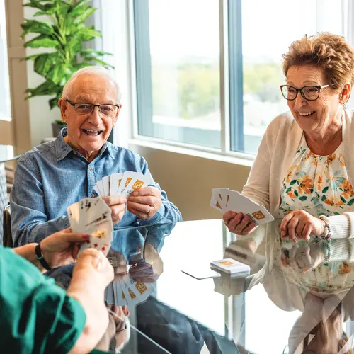 Seniors are playing card with happy smile / Les seniors jouent aux cartes avec un sourire joyeux