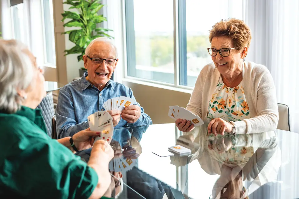 Seniors are playing card with happy smile / Les seniors jouent aux cartes avec un sourire joyeux