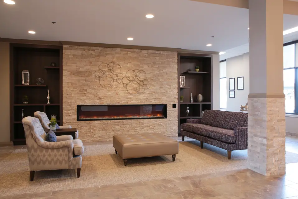 Cozy lounge with modern fireplace and seating at Chartwell Dorchester Terrace / Salon chaleureux avec foyer moderne et fauteuils à Chartwell Dorchester Terrace