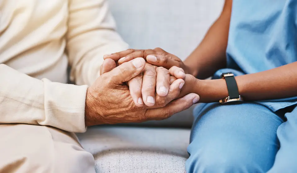 Close up of a senior and care giver holding each others' hands / Gros plan sur une personne âgée et un aidant se tenant la main