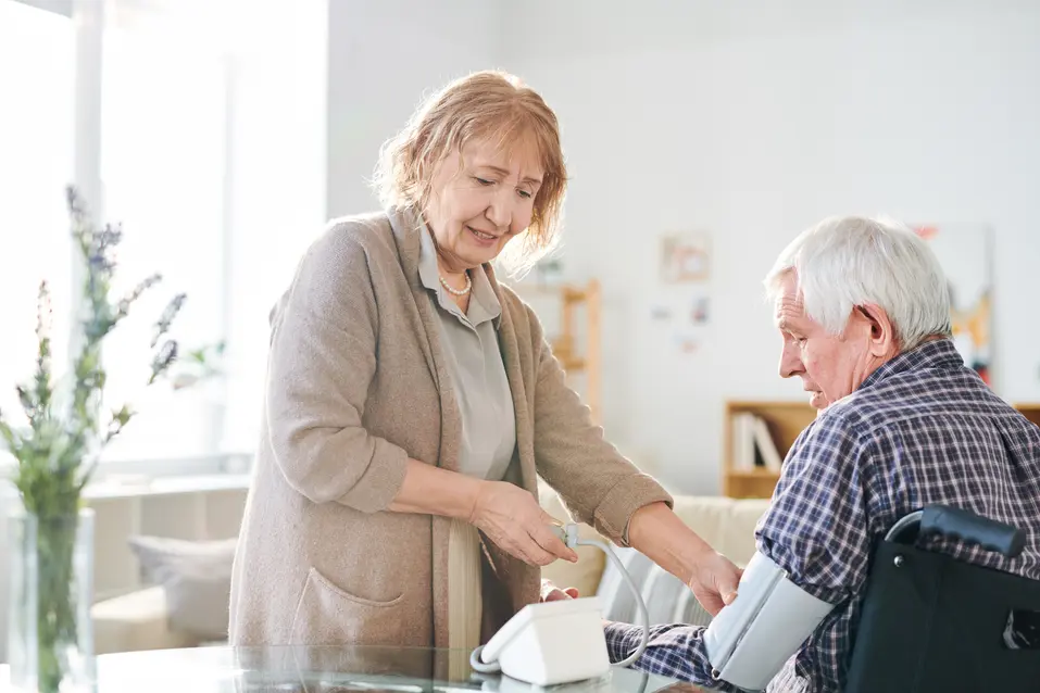 Senior woman is taking blood pressure of her husband / Une femme âgée prend la tension artérielle de son mari