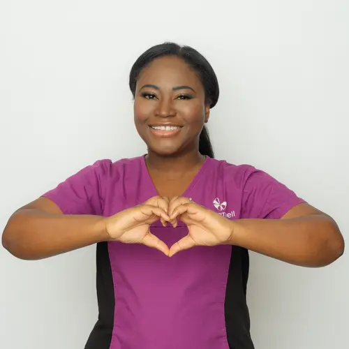 Chartwell staff in her purple uniform making a heart with her hands / L'employée de Chartwell en uniforme violet fait un cœur avec ses mains