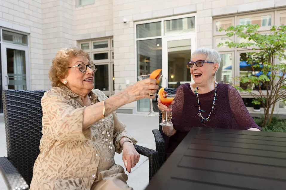 Twoseniorladiessmilingandcheersing