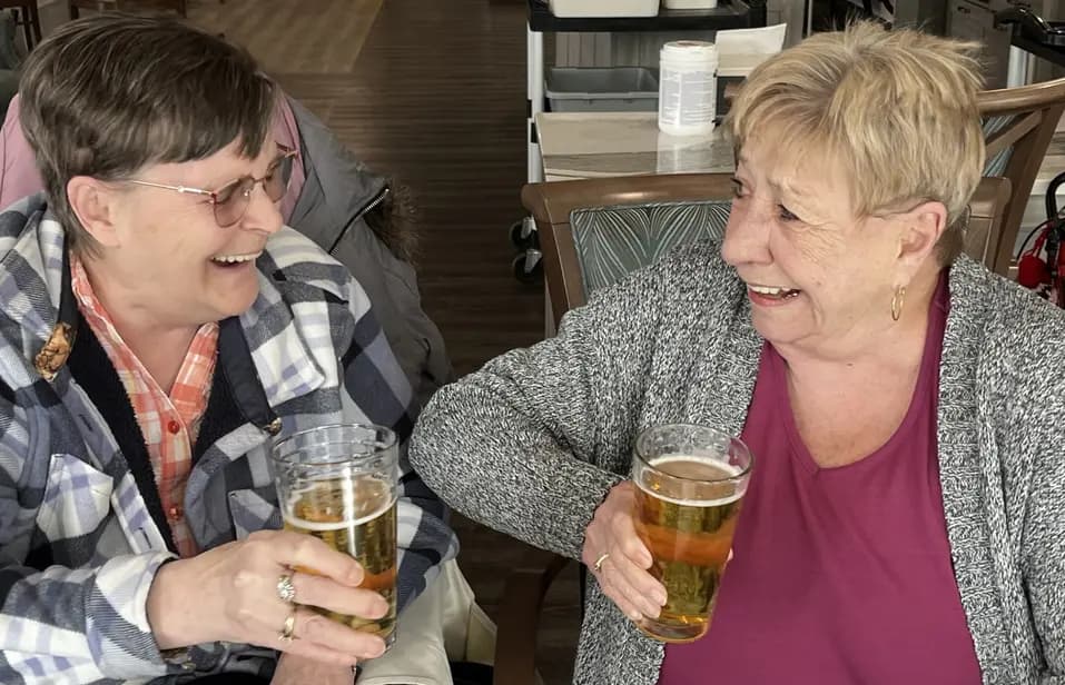 Residents enjoying drinks together at a table / Résidents prenant un verre ensemble à une table