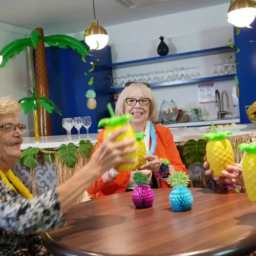 Senior ladies dressed up in Caribbean theme and enjoying drinks