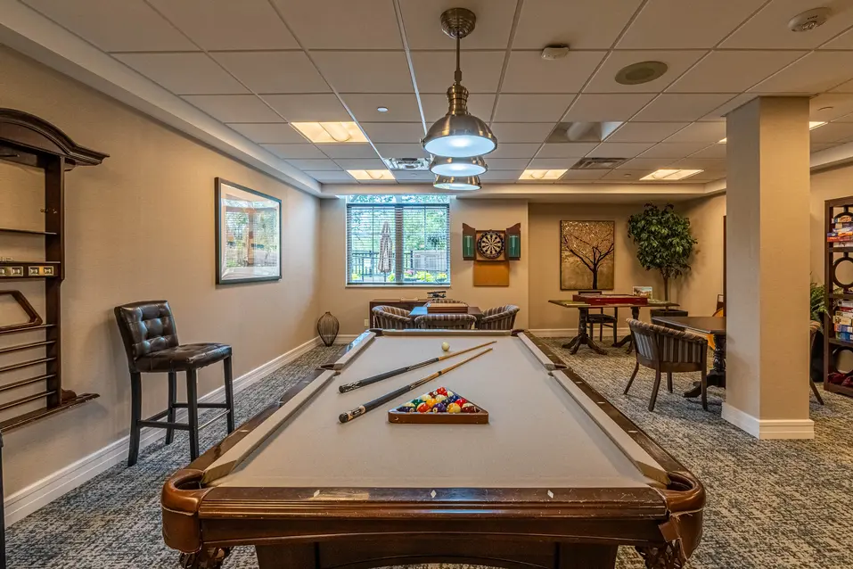 Chartwell Palermo Village billiards room. This photo has a pool table along with all the items you would need to play.