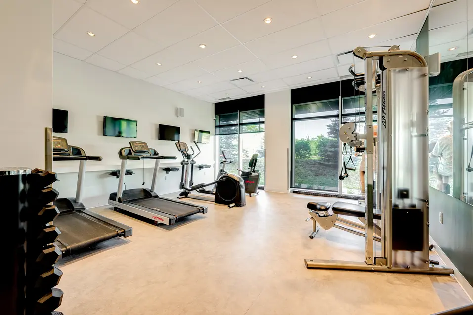 Salle de sport avec équipement de fitness à Chartwell Des Milles-Îles / Gym with fitness equipment at Chartwell Des Milles-Îles