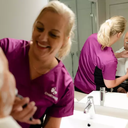 Chartwell care staff helping the senior resident with the shave / Le personnel soignant de Chartwell aide le résident âgé à se raser.
