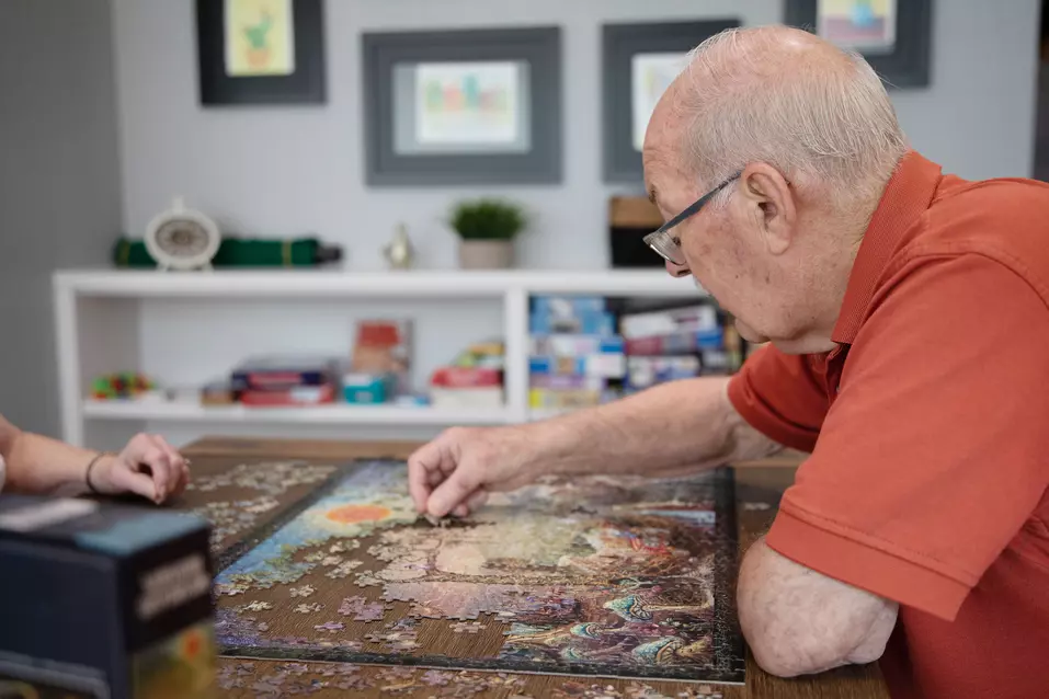 Senior resident engrossed in finishing a big puzzle