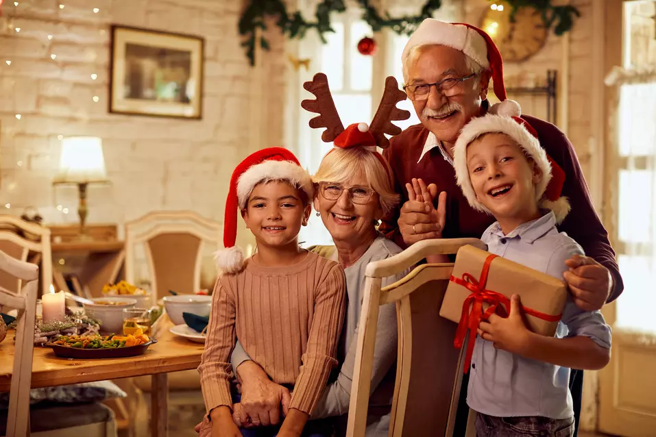 Happily smiling grandchildren and their grandparents in front of a holiday dinner / Petits-enfants et grands-parents souriants devant un dîner de fête