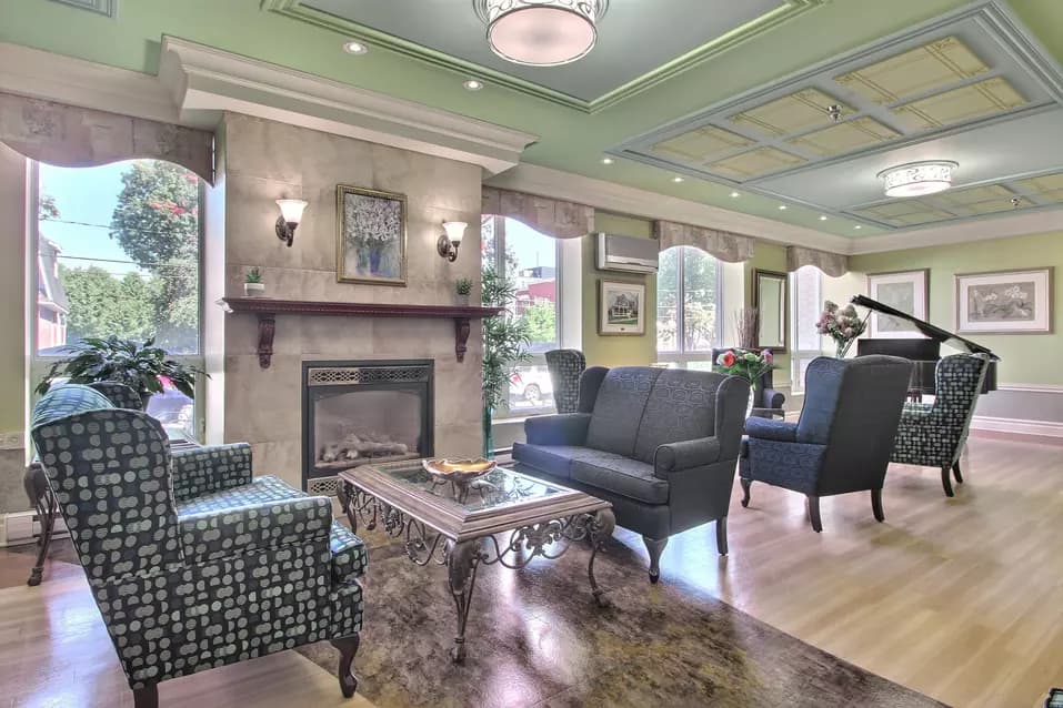 Salon commun avec fauteuils et foyer Chartwell Domaine Notre-Dame résidence pour retraités retirement residence Common room with fireplace and armchairs