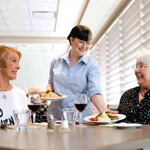Chartwell staff server serving food to the Chartwell senior residents in Dinning room