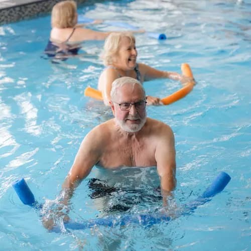 Seniors are enjoying aquafit together in a pool / Des personnes âgées s'adonnent ensemble à l'aquagym dans une piscine
