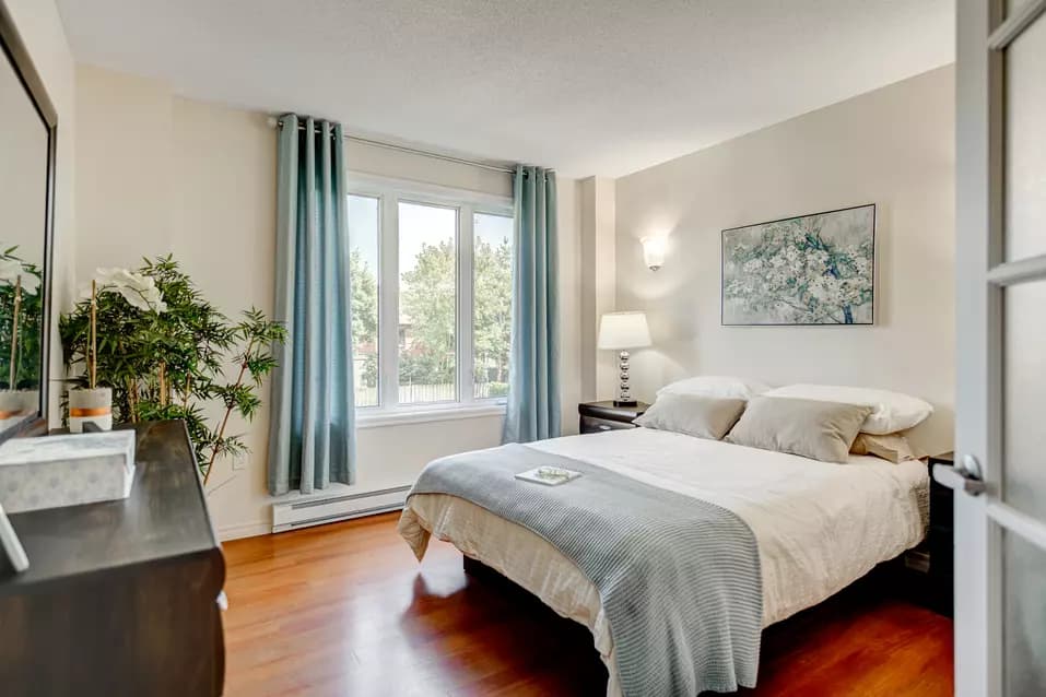 Chambre à coucher avec grand lit dans appartement modèle Chartwell Manoir Archer résidence pour retraités