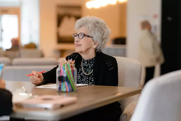 Chartwell Senior resident enjoying art session by colouring a picture
