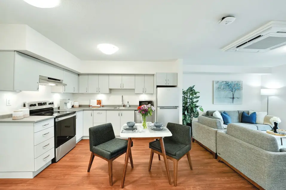 View of in suite kitchen, dining area and living room with ceiling air conditional at Chartwell Ridgepointe / Vue de la cuisine, de la salle à manger et du salon de la suite avec climatisation au plafond à Chartwell Ridgepointe