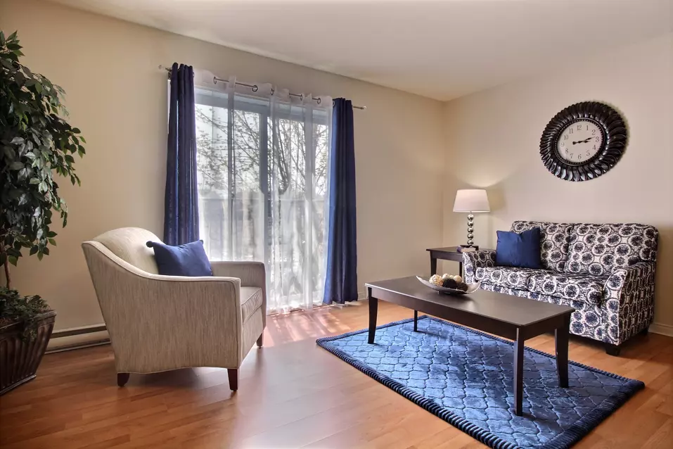 Salon avec porte-patio dans appartement modèle Chartwell Oasis St-Jean résidence pour retraités