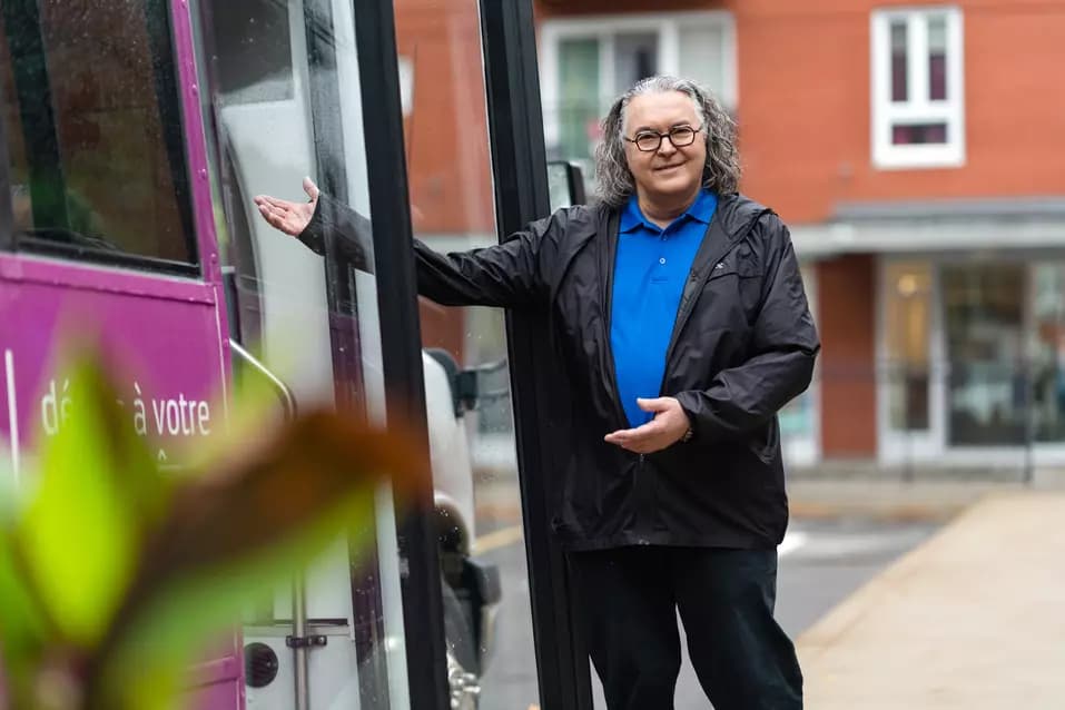 Chartwell's shuttle bus driver is showing welcoming hand gesture / Le chauffeur de la navette Chartwell fait un geste de bienvenue de la main