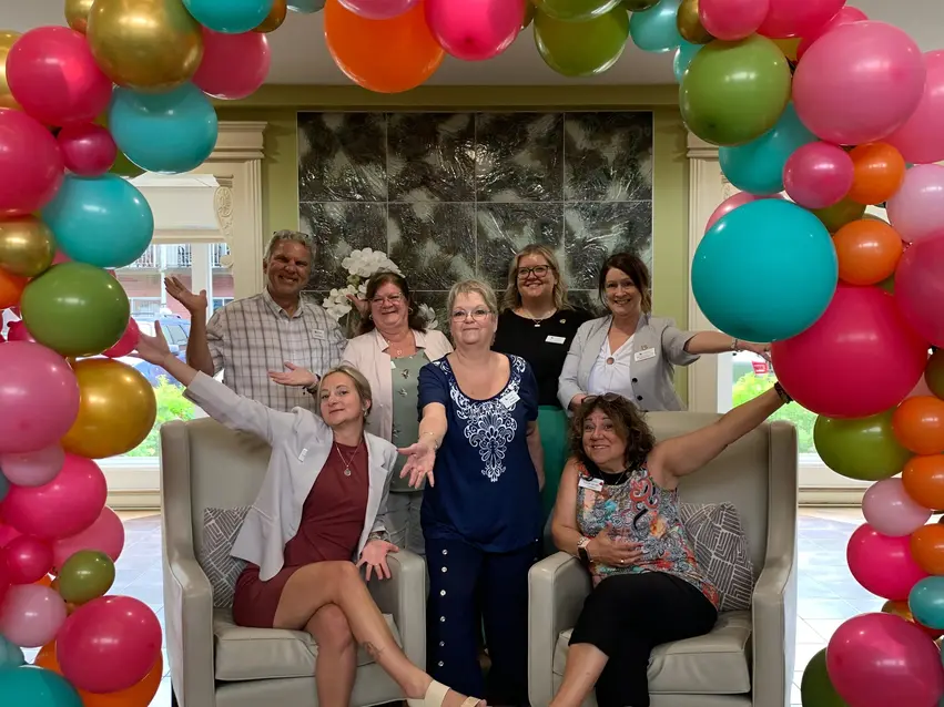 Staffs at Chartwell resident are posing in front of a balloon arch / Le personnel de la résidence Chartwell pose devant une arche de ballons