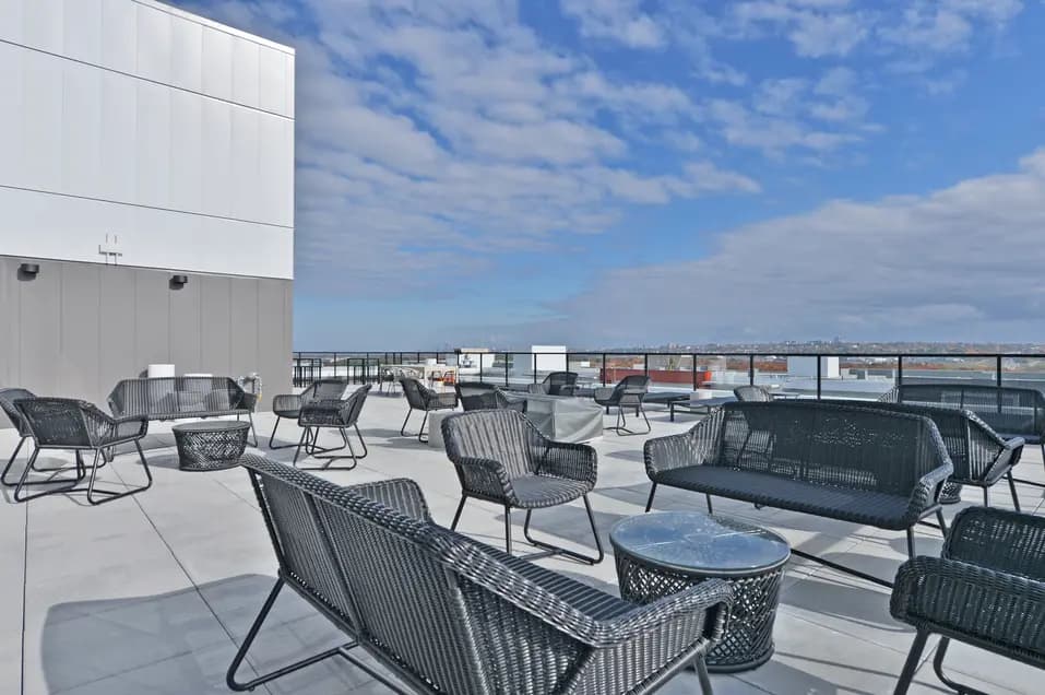 Terrasse sur le toit avec bancs et tables à l'appartement Le Jules-Verne / Rooftop patio with patio benches and tables at Le Jules-Verne Apartment