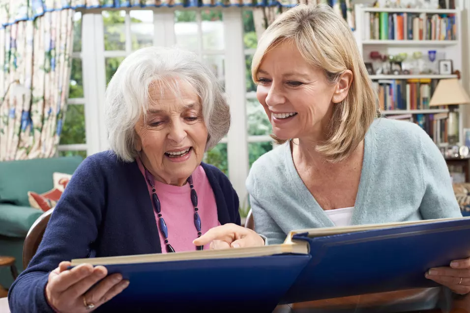 Senior woman with daughter looking at photos