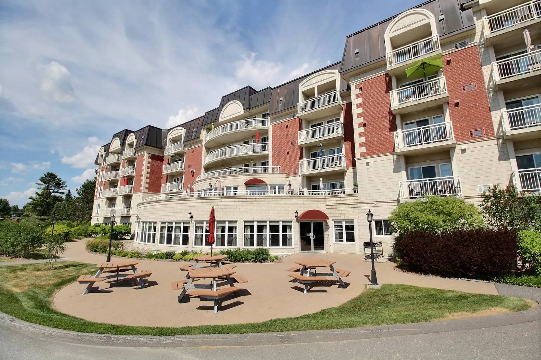 Aire de tables à pique-nique avec verrière en arrière-plan Chartwell Seigneuries du carrefour résidence pour retraités