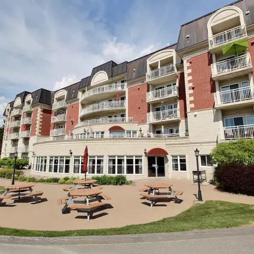 Aire de tables à pique-nique avec verrière en arrière-plan Chartwell Seigneuries du carrefour résidence pour retraités